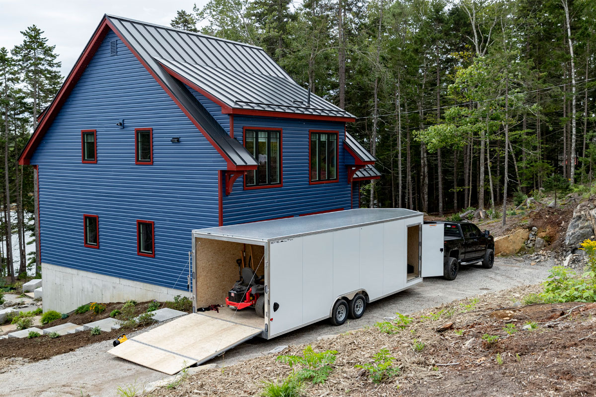 Opened Enclosed 8.5 Wide Cargo Trailer In Front Of Blue House