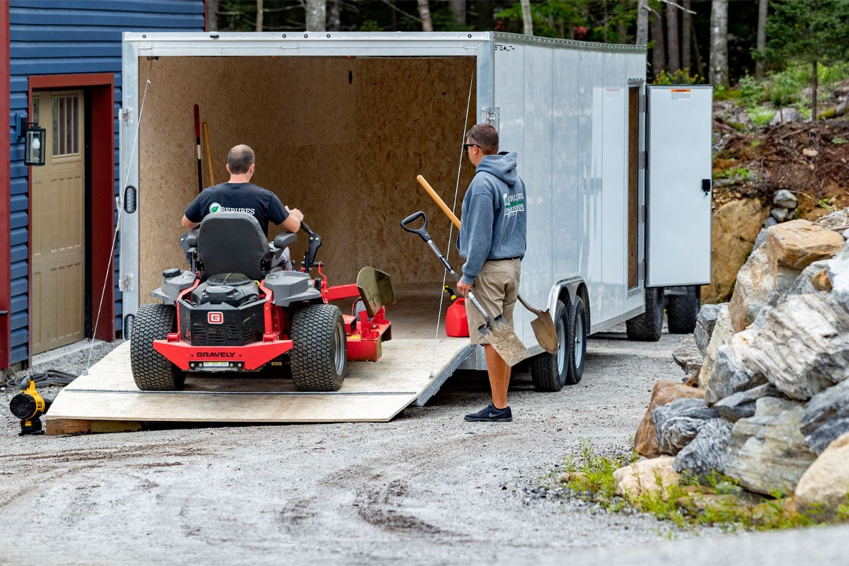 Person Loading Tractor Into Enclosed 8.5 Wide Cargo Trailer
