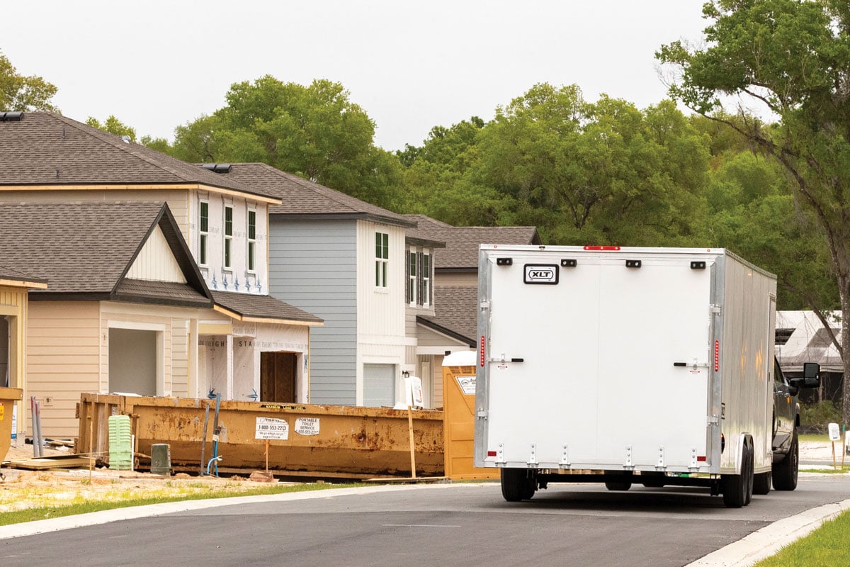 Rear view of white XLT Pro Car Hauler driving through neighborhood