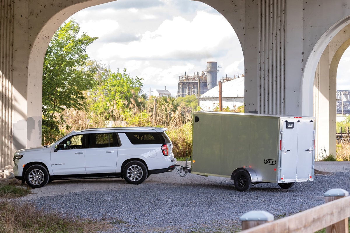 White SUV parked under bridge with Gray trailer attached